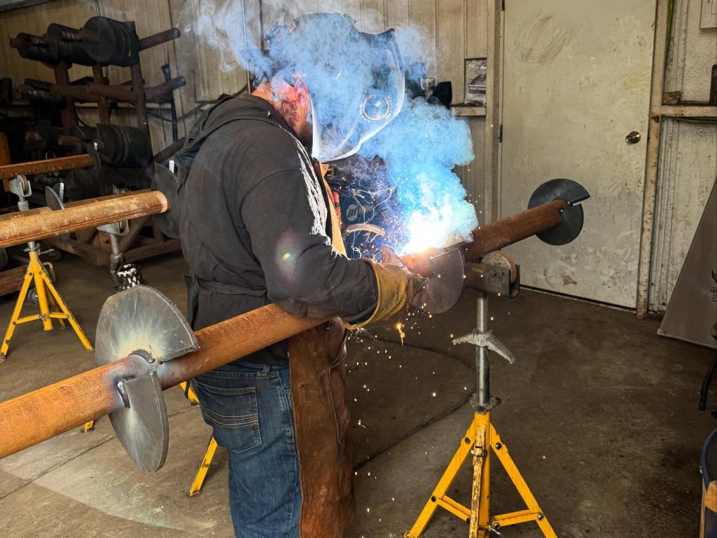 FnD Piers team member welding a helical pier