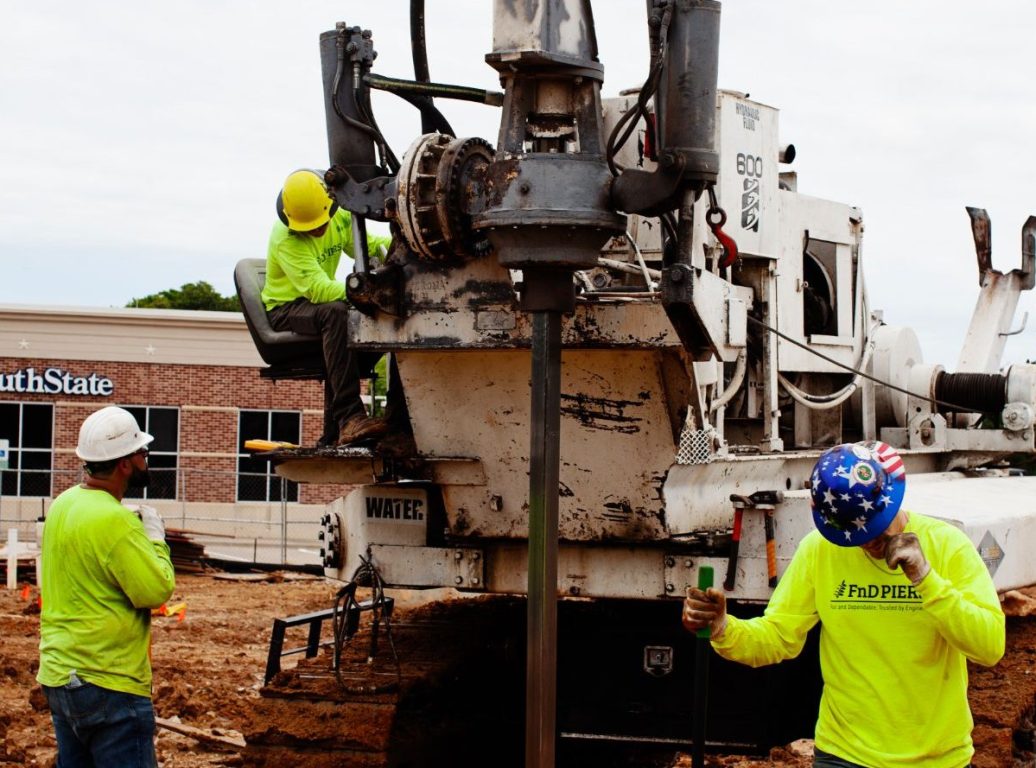 FnD Piers helical pier drilling rig at work on a commercial foundation installation