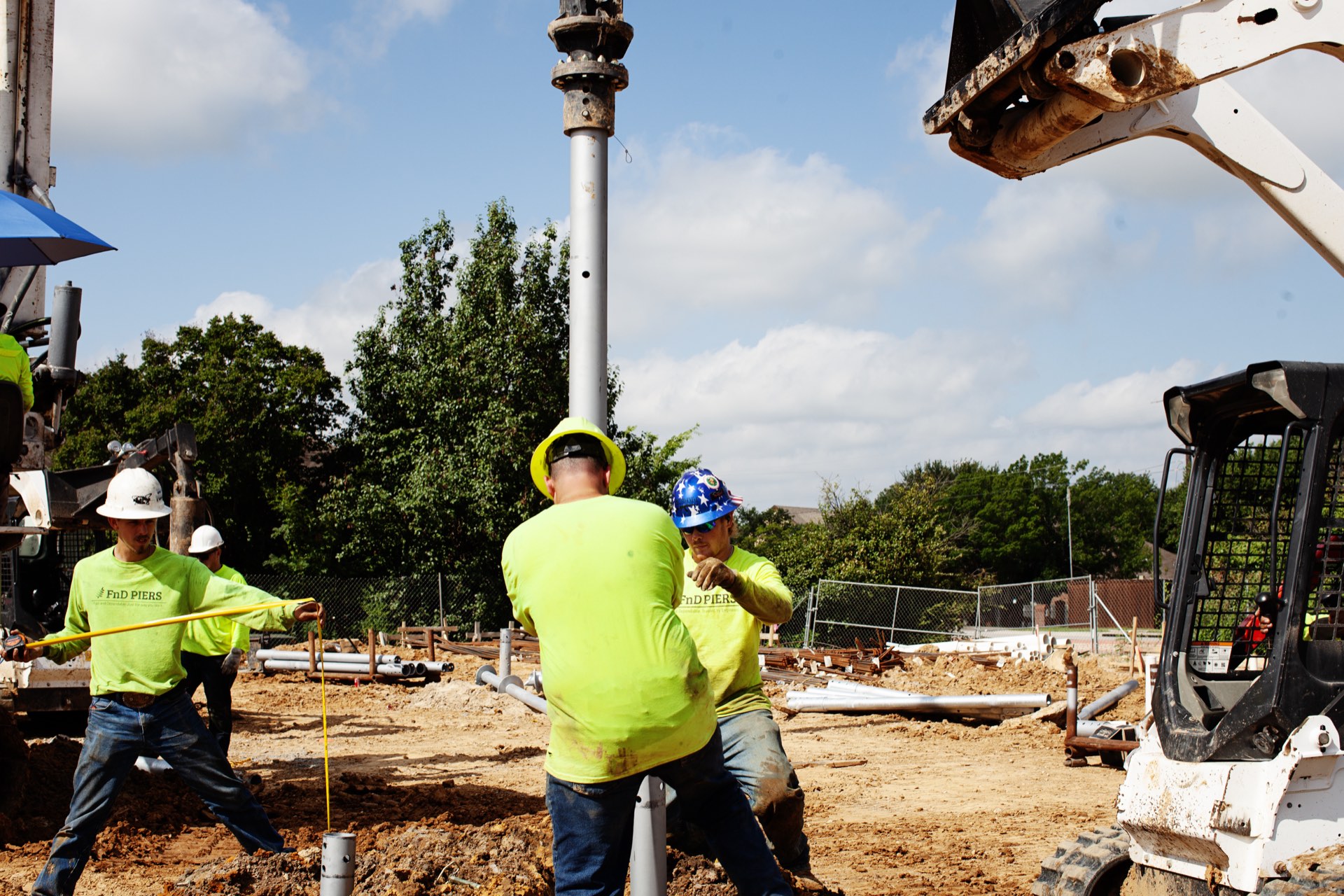 FnD Piers crew installing a helical pier with their skid-steer rig at a residential jobsite in Texas