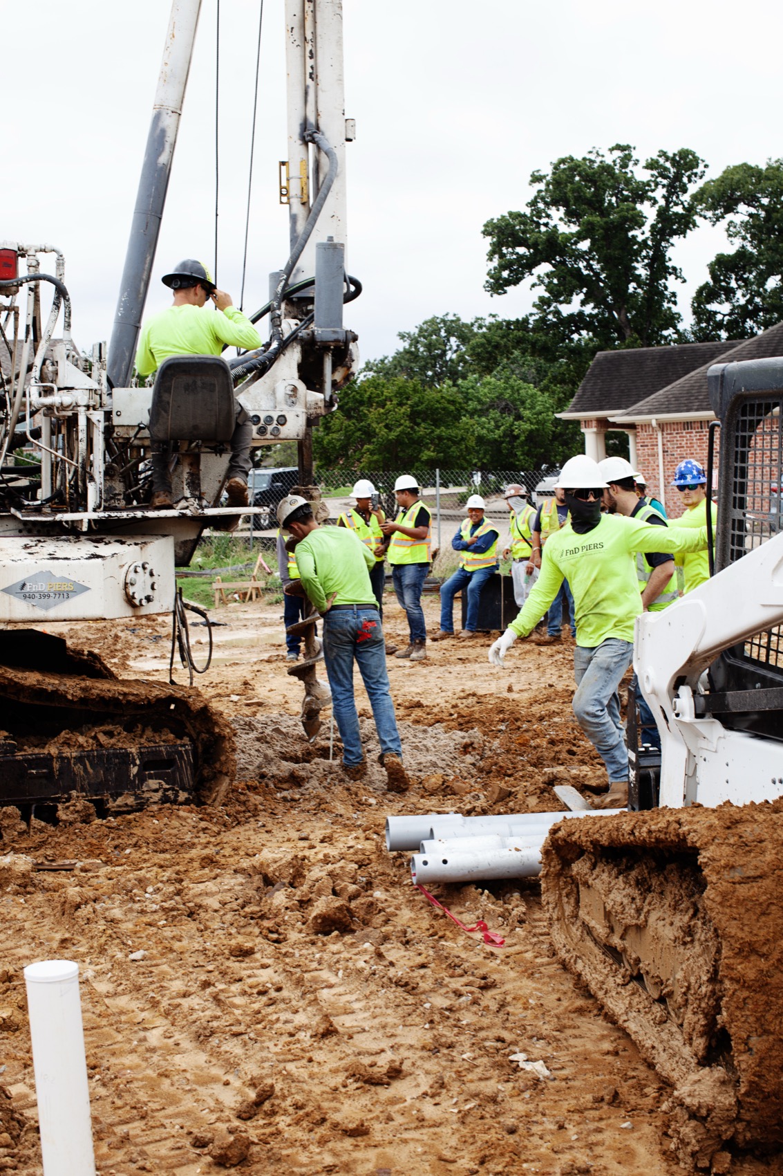 The full FnD Piers crew installing helical piers with their branded rig at a residential jobsite in Texas