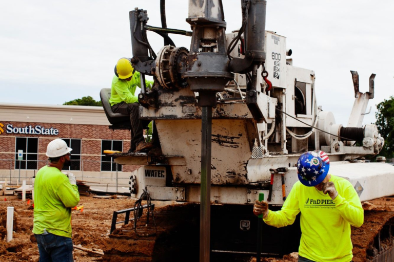 FnD Piers helical pier drilling rig at work on a commercial foundation installation