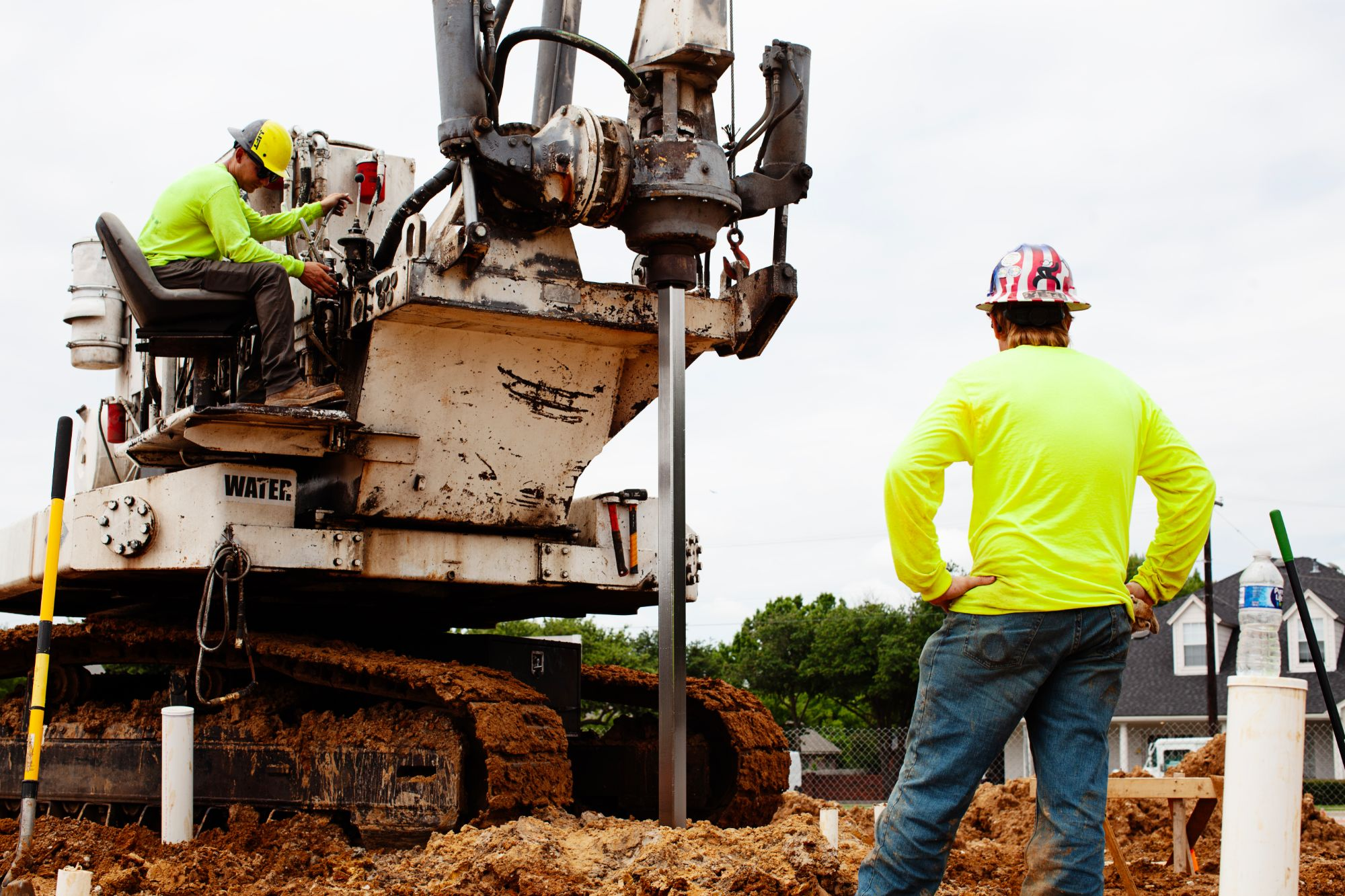 FnD Piers helical pier drilling rig driving a pier at a new construction jobsite, serving Garland, TX