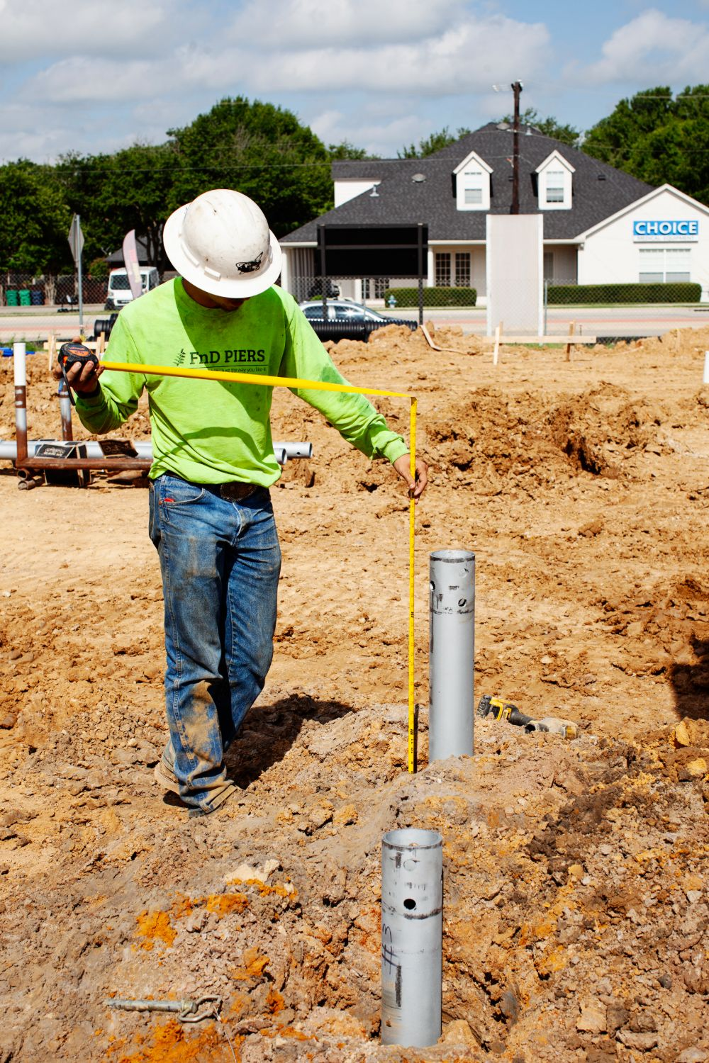 FnD Piers technician measuring foundation elevation during a survey, serving Weatherford, TX