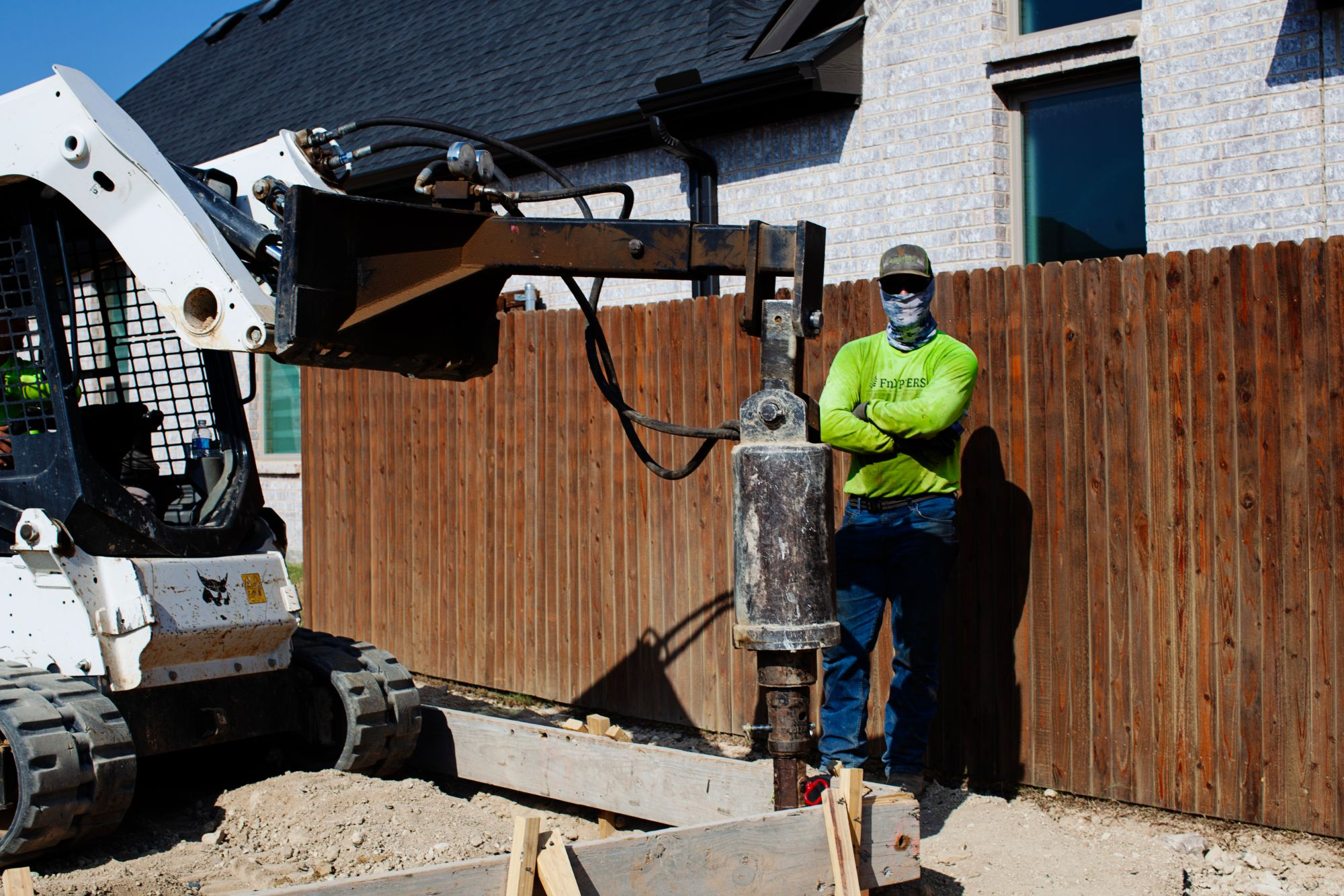 FnD Piers technician with helical pier installation equipment at a new construction site, serving Haltom City, TX
